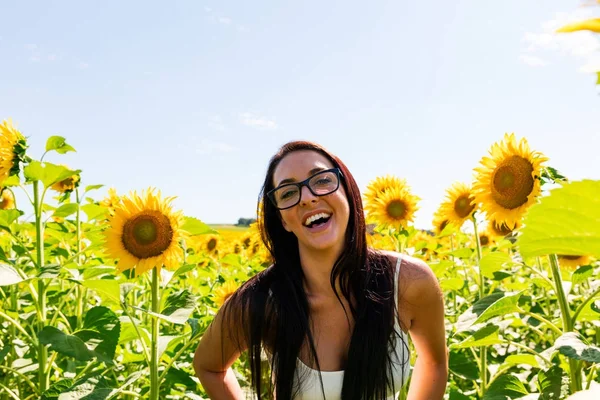 Śmiejąc się atrakcyjna kobieta w Słonecznikowe pole — Zdjęcie stockowe