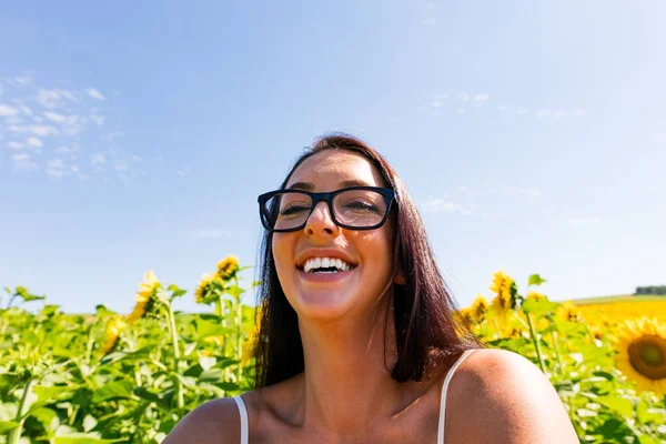 Aantrekkelijke vrouw in zonnebloem veld lachen — Stockfoto