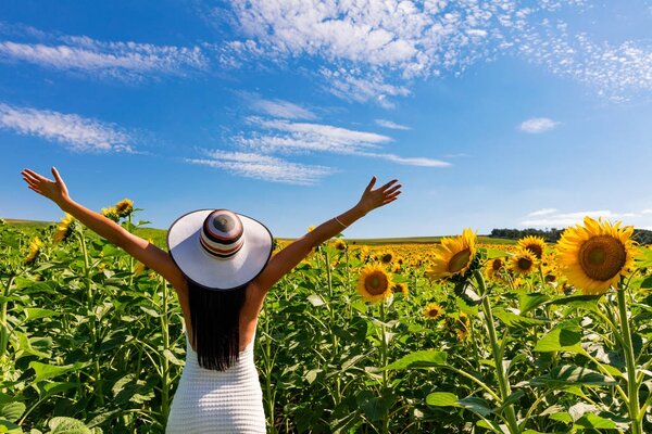 Happy attractive woman in sunflower field