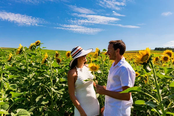 Gelukkige paar in zonnebloem veld — Stockfoto