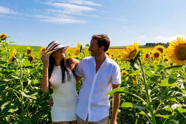 Gelukkige paar in zonnebloem veld — Stockfoto