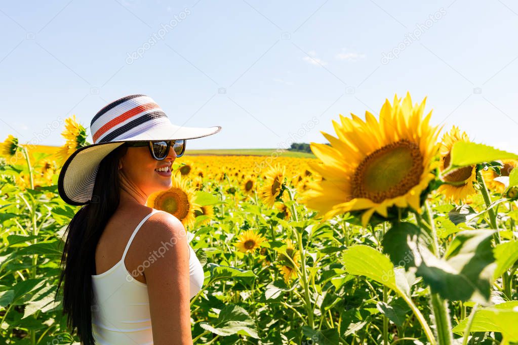 Happy attractive woman in sunflower field