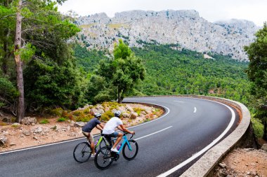 Cyclists riding up the Puig Major peak in Majorca clipart