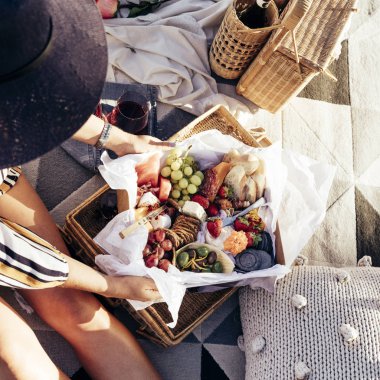 Karışık yemek tabağı ve şarapla gün batımında romantik piknik kurmak