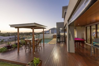 Arka bahçe veranda ayarı yüzme havuzlu lüks ev gün batımında