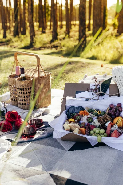 Romantic picnic set up with mixed food platter and wine at sunset