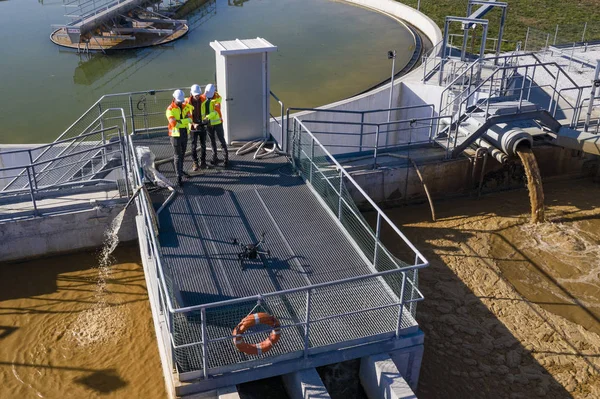 Engineers assesing waste treatment plant with drone — 图库照片