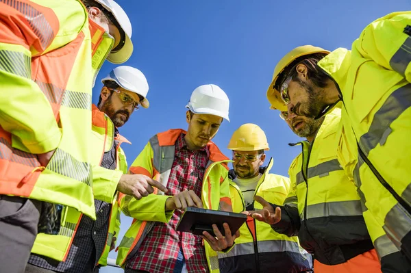 Engineers and workers assesing wastewater plant — 스톡 사진