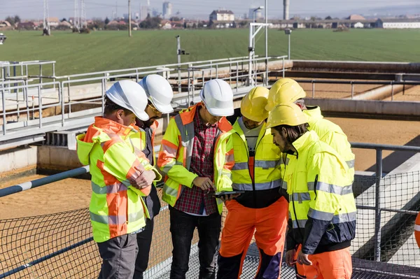 Engineers and workers assesing wastewater plant — Stock Photo, Image