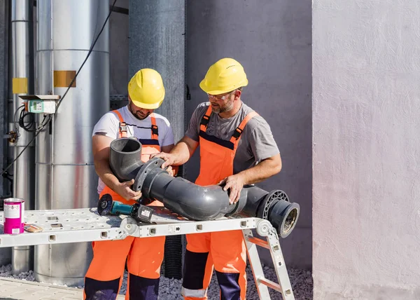 Workers assembling PVC piping — 스톡 사진