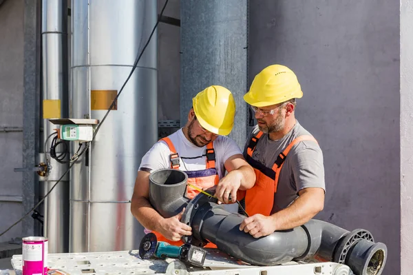 Workers assembling PVC piping — 스톡 사진