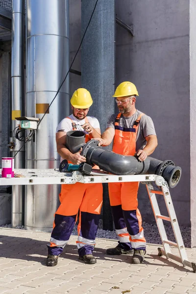 Workers assembling PVC piping — 스톡 사진