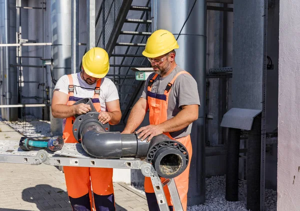 Workers assembling PVC piping — 스톡 사진