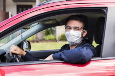 Young male driver inside car with protective face mask clipart