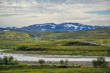 Çim kaplı tepe ve kısmen Alta, Norveç'in şehirden karla kaplı dağ güzel manzara