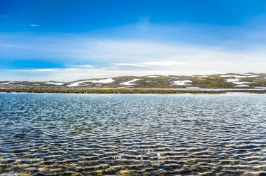 Güzel manzara ve Norveç, tepeler ve dağ toplayan beyaz kar ve Mavi Göl ile kısmen kapsanan 