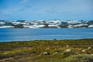 Güzel manzara ve Norveç, tepeler ve dağ toplayan beyaz kar ve Mavi Göl ile kısmen kapsanan 