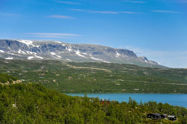 Beautiful landscape and scenery of Norway, the hills and mountain covered partially with white snow and blue lake — Stock Photo, Image