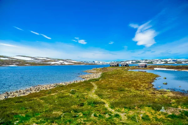 언덕 및 산의 아름 다운 풍경으로 둘러싸여 고립 된 집 흰 눈, 노르웨이 부분적으로 덮여 — 스톡 사진