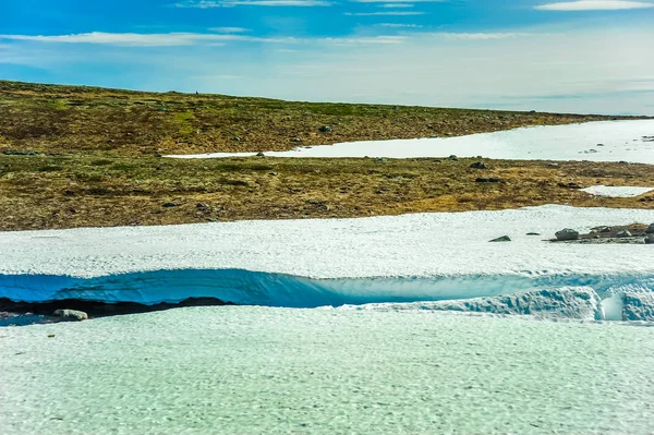 Piękny krajobraz i krajobrazy Norwegii, wzgórza i góry pokryty częściowo biały śnieg i błękitne jezioro — Zdjęcie stockowe