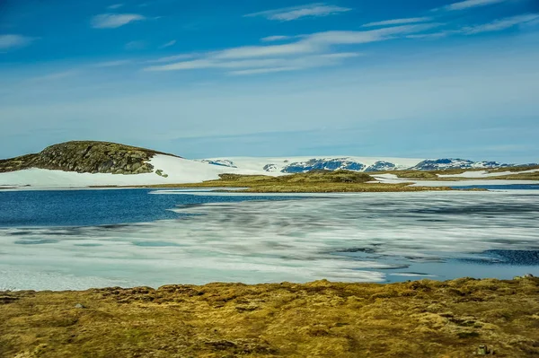 Krásná krajina a příroda Norska, kopce a hory pokryté částečně bílý sníh a modré jezero — Stock fotografie