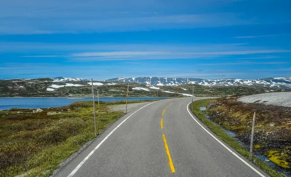 Krásná krajina a příroda Norska, kopce a hory pokryté částečně bílý sníh a modré jezero — Stock fotografie