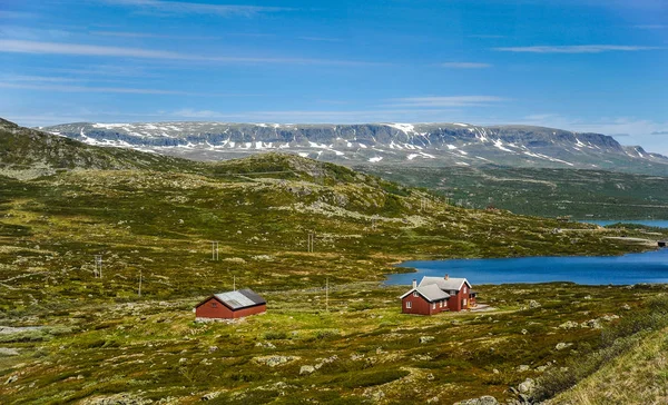 Bellissimo paesaggio e scenario della Norvegia, le colline e le montagne parzialmente coperte di neve bianca e lago blu — Foto Stock