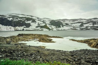 Güzel manzara ve sahne görünümünü Norveç, tepeler ve kısmen beyaz kar ve göl ile kaplı dağ 