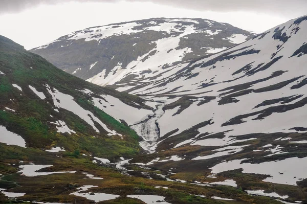 Piękny widok krajobraz i krajobrazy Norwegii, wzgórza i góry częściowo pokryte białym śniegiem — Zdjęcie stockowe