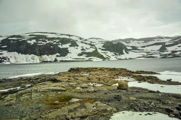 Beau paysage et vue sur la Norvège, les collines et la montagne partiellement recouvertes de neige blanche et le lac — Photo