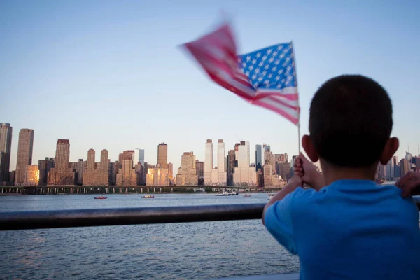 소년은 맨해튼-뉴욕 (뉴욕)-아메리카 합중국에서 보기와 허드슨 강에 독립 기념일 동안 미국 국기를 보유 — 스톡 사진