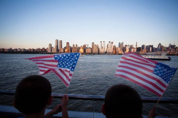 Två barn håller en amerikansk flagga under självständighetsdagen på Hudsonfloden med utsikt på Manhattan - New York City (Nyc) - Sverige — Stockfoto