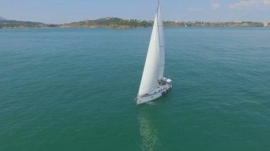 Açık denizde güneşli gün yelken yat. Yatçılık. Yat video. Yat dron video. Yelken hava video. Yelkenli yat.