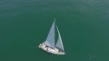 Açık denizde güneşli gün yelken yat. Yatçılık. Yat video. Yat dron video. Yelken hava video. Yelkenli yat.