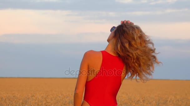 Girl in a field in a red swimsuit. Slowmo 120fps — Stock Video