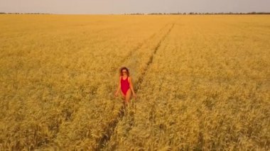 Genç güzel kız kırmızı alanda yürüyüş. Havadan görünümü. 4k