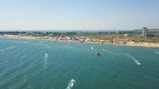 Vista aérea del kitesurf deporte extremo con el viento libre. Hermosa vista superior de la bonita playa. Muchas cometas. — Vídeos de Stock