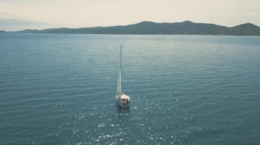 Yat manzaralı, güzel adaların yakınında. Arka planda güzel bulutlar var. Denizde lüks bir yat..
