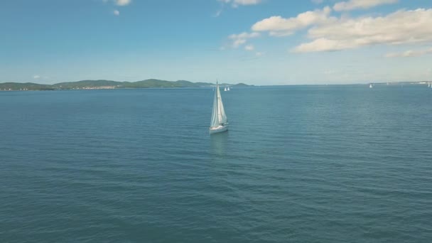 美しい島の近くにヨットセーリングの空中ビュー。背景に美しい雲。海の高級ヨット. — ストック動画