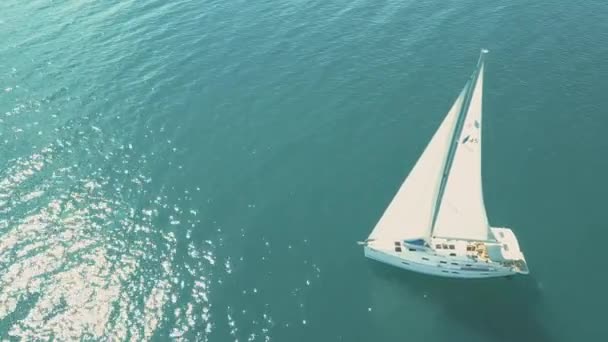 Letecký pohled na jachtu plachtění v blízkosti krásných ostrovů. Krásné mraky v pozadí. Luxusní jachta v moři. — Stock video