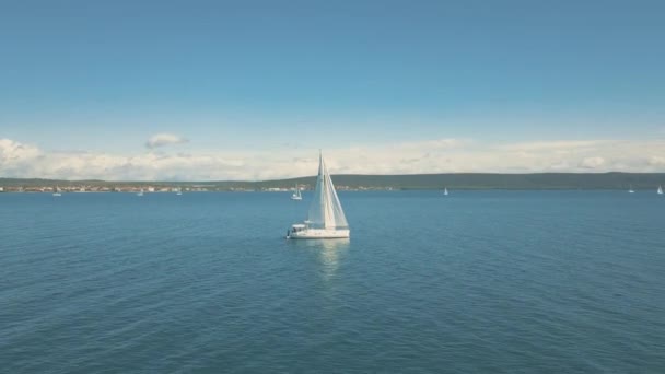 在美丽的岛屿附近航行的游艇的航景。后面是美丽的云彩。豪华游艇在海里. — 图库视频影像