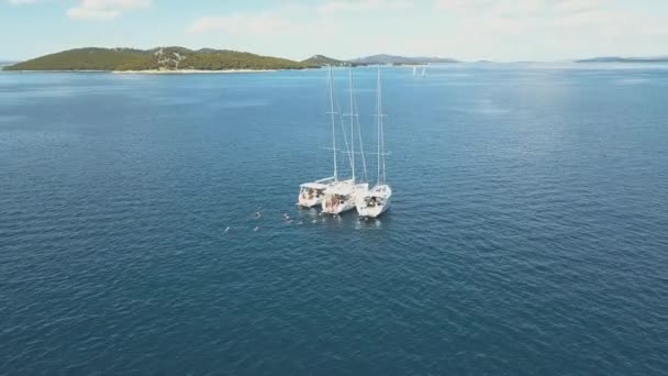 Vue aérienne de trois voiliers sont connectés, près de belles îles. Beaux nuages en arrière-plan. Yachts de luxe dans la mer. Les gens nagent près des yachts 