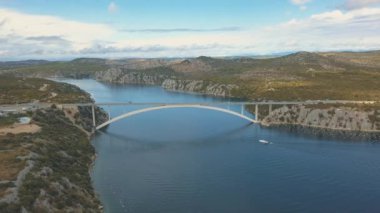 Köprü ve Denizi Adaları çevresinde hava panorama görünüm. Güzel manzara ile arasında köprü mavi denizi ile çevrili. Güneşli bir gün Krka nehirde Hırvatistan üzerindeki trafik köprüsüyle otobanı.
