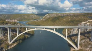 Köprü ve Denizi Adaları çevresinde hava panorama görünüm. Güzel manzara ile arasında köprü mavi denizi ile çevrili. Güneşli bir gün Krka nehirde Hırvatistan üzerindeki trafik köprüsüyle otobanı.