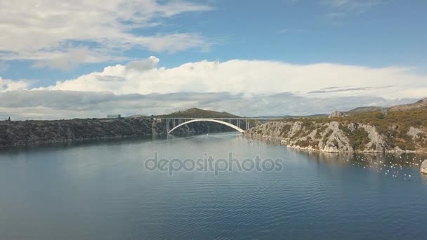 Letecké panorama pohled s mostem a moře kolem ostrovů. Krásná krajina s modrým mořem s mostem mezi. Autostrada most s přenosy přes řeku Krka ve slunečný den v Chorvatsku. — Stock video