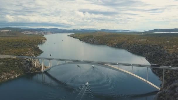 Luchtfoto panoramisch uitzicht met brug en de zee rond de eilanden. Mooi landschap, omgeven met blauwe zee met brug tussen. Autostrada brug met verkeer over de rivier Krka op zonnige dag in Kroatië. — Stockvideo