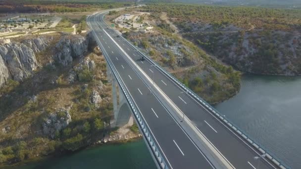 橋と島の周りの海の空中パノラマ ビュー。間のブリッジと青い海に囲まれた美しい風景。晴れた日にクロアチアのクルカ川上のトラフィックを高速道路橋. — ストック動画