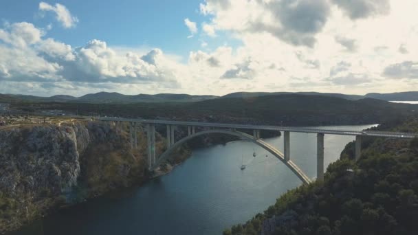 Luchtfoto panoramisch uitzicht met brug en de zee rond de eilanden. Mooi landschap, omgeven met blauwe zee met brug tussen. Autostrada brug met verkeer over de rivier Krka op zonnige dag in Kroatië. — Stockvideo