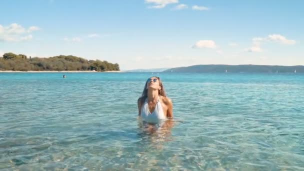 Piękna dziewczyna beztroski, ciesząc się jej styl życia plaży chodzenie przez ocean. Slowmo 120 fps — Wideo stockowe