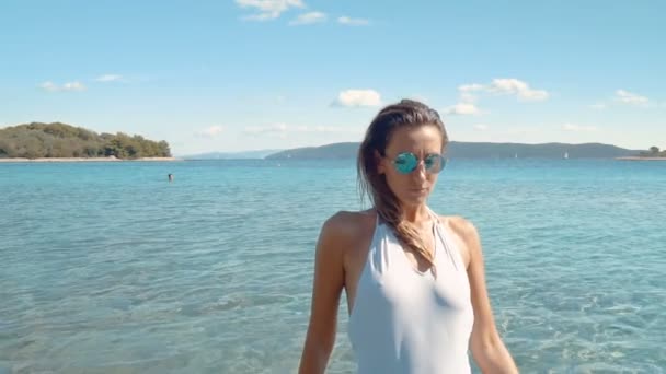Vackra sorglös flicka njuter hennes stranden livsstil walking av havet. Slowmo 120 fps — Stockvideo